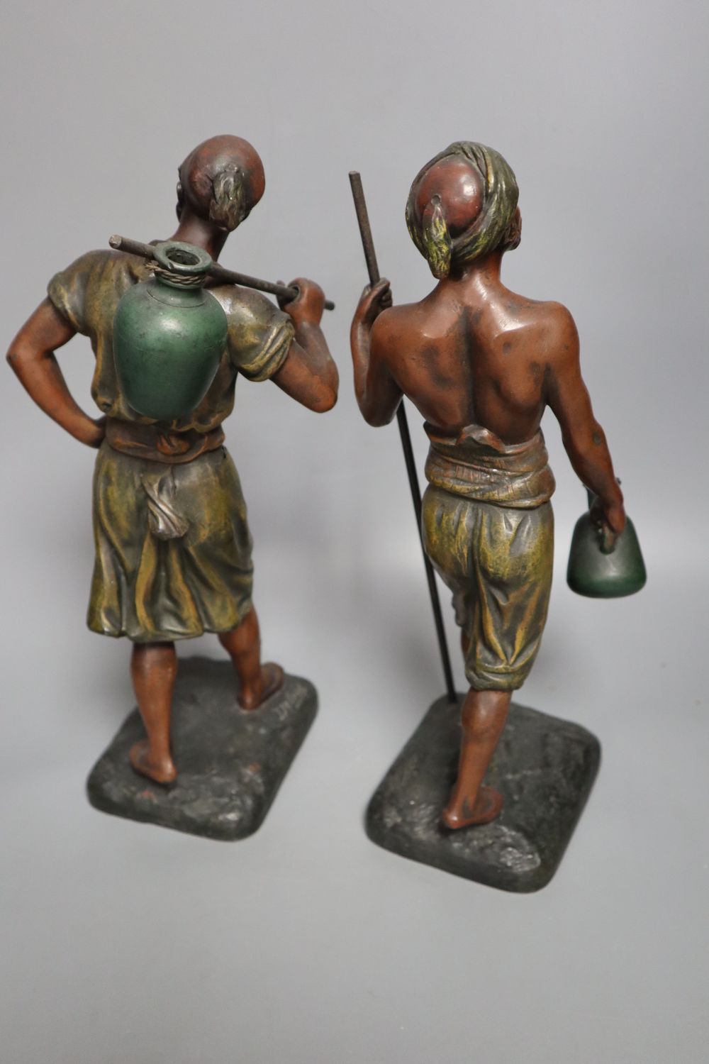 A pair of late 19th century painted bronze labourer figures after Debut, 12in., and a bronze figure of a playful girl, on marble plinth